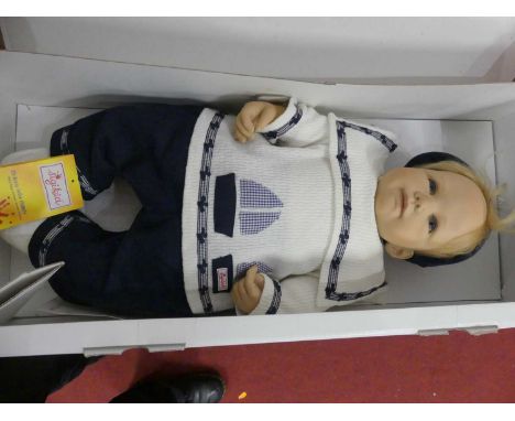 A Sigikid boxed toy doll; together with a musical teddy-bear with porcelain face 