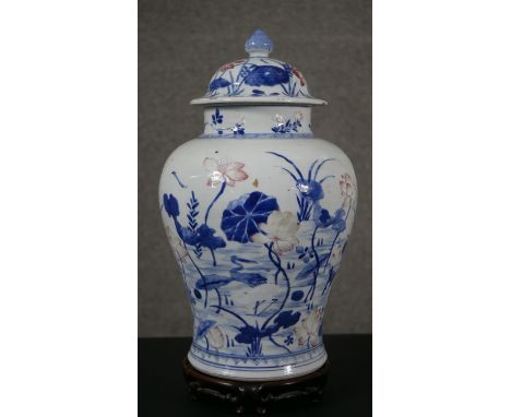 A Chinese baluster form porcelain jar and cover, blue and white, painted with flowers and storks, bearing an old paper label 