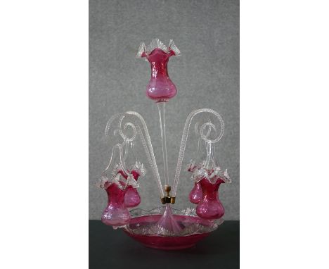 A Victorian ruby glass epergne with central stem and four scrolling branches each with hanging basket on flared dish base. H.