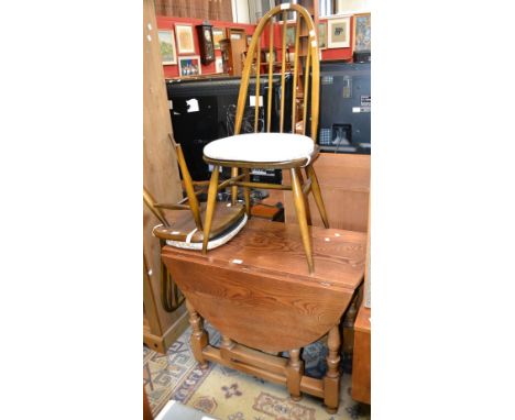 An oak dropleaf table; two Ercol spindle back chairs 