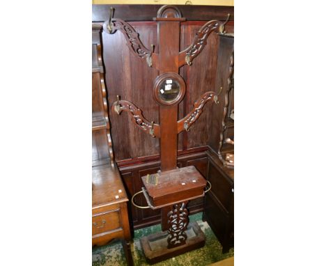 A Victorian mahogany tree hall stand, four reticulated branches, circular mirror, glove box and stick stand to base.