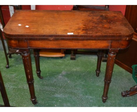 A Regency mahogany card table, fold over top, opening to green baize playing surface, tapering legs, brass casters