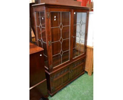 An Old Charm display cabinet, lead glazed doors to top, carved panel doors to base 