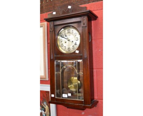 A 1940's mahogany cased wall clock, arch glazed panel door, Arabic numerals 