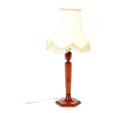 An Art Deco walnut table lamp, having octagonal column and base with silk fringed shade, 59cm high overall