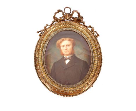 A late 19th Century oval portrait miniature,&nbsp;of a young gentleman contained in brass ribbon tied decorated easel frame, 
