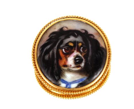 A Victorian yellow metal and enamel circular&nbsp;brooch,&nbsp;inset with a study of a King Charles Spaniel, inscribed verso 