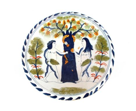 A Bristol Delftware "Adam and Eve" decorated charger,&nbsp;painted in dark blue and green, serpent and fruit picked out in ye