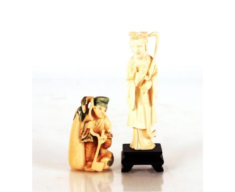 A Chinese natural&nbsp;stained ivory Netsuke,&nbsp;depicting a figure with an axe; and a carved ivory figure of a Deity on wo