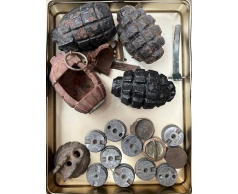 A collection of inert grenade parts including base plugs and Mills