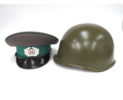 An East German Border Guard visor cap together with a Cold War era Russian Soviet helmet (2)