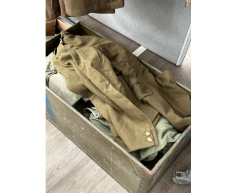 A box containing a large quantity of uniform including post war Army Service dress jacket, great coat and overalls