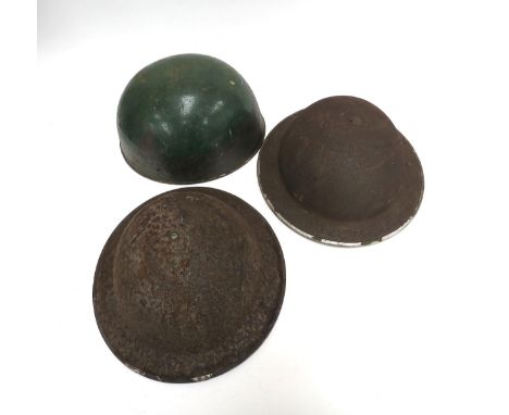 A WWII Brodie helmet dated 1942, another heavily worn and a motorcycle dispatch rider's helmet shell (3)