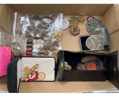 A collection of military badges and insignia including cap badges, Women's Land Army embroidery, cloth insignia and a Rotary 