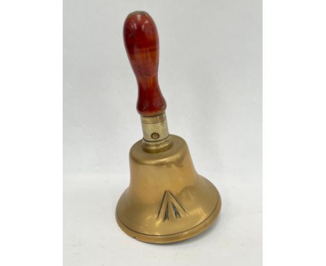 A brass hand bell with War Department broad arrow mark, polished