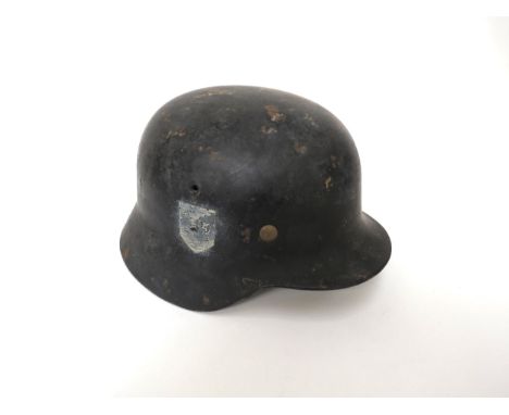A German M40 type helmet, black painted with signs of both shield-form decals, with brown leather liner and chinstrap, shell 