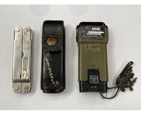 A US military signalling light together with a leatherman multitool in leather case