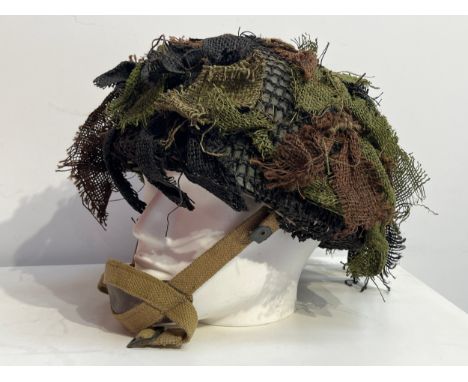 A WWII British 1944 dated paratroopers / airborne steel combat helmet, with its original green paint finish to the shell whic