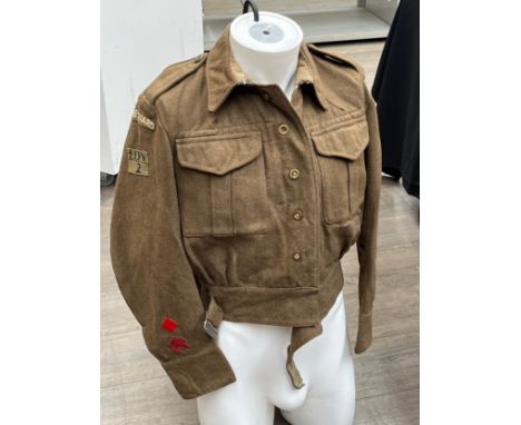 A WWII battledress blouse with Home Guard insignia including 2nd London Home Guard, label removed to lining but marked with l
