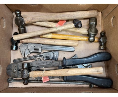 A box of military tools including hammers, wrenches and a set of wire cutters