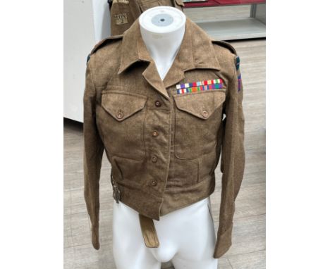 A WWII British 1940 pattern battledress blouse, size no. 10, dated 1942, with medal bars for WWII, MC and GSM, insignia for 5