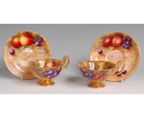 A pair of Royal Worcester porcelain fruit painted teacups and saucers, by Harry Ayrton and each piece signed, each decorated 