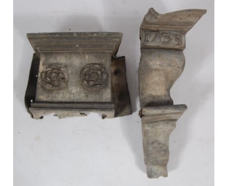 An 18th century lead water hopper, wall mounted and decorated with two flowerheads, h.34cm, w.41cm; and one other corner wate