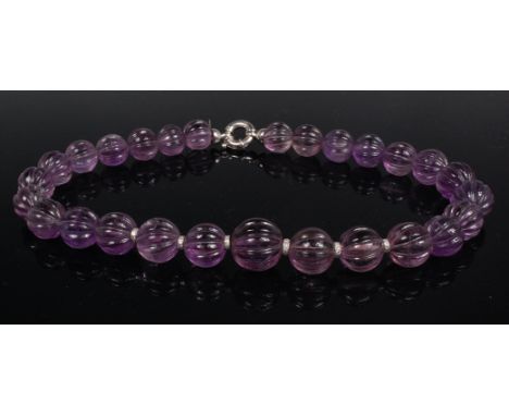 A contemporary beaded amethyst necklace, the graduated beads with flutings, the largest dia. 1.8cm, and six with white metal 