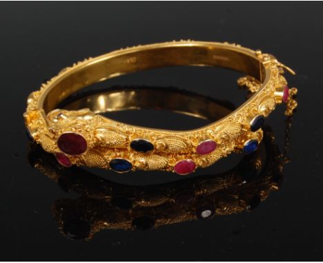 A Chinese 22ct yellow gold ruby and sapphire set serpent-head bangle, having hinged action, safety chain, marked EAO, with fu