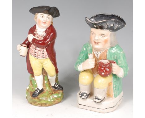 A 19th century Staffordshire Toby jug, modelled standing with a pipe and pitcher of ale, h.27cm; and one other of a seated To