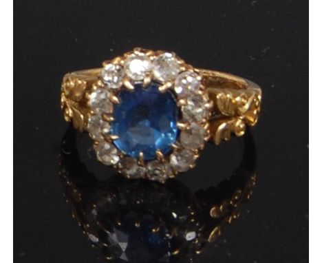 A late Victorian yellow gold sapphire and diamond cluster ring, the claw set antique cushion cut sapphire within a surround o