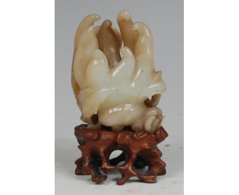 A Chinese Qing Dynasty carved jade finger citron, the back carved with two bats,  of celadon and russet brown colour, on hard