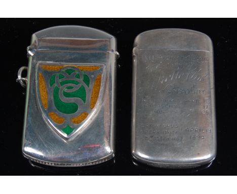 An Edwardian silver vesta, of plain rectangular form, having shield shaped cartouche with blue and green enamelled decoration