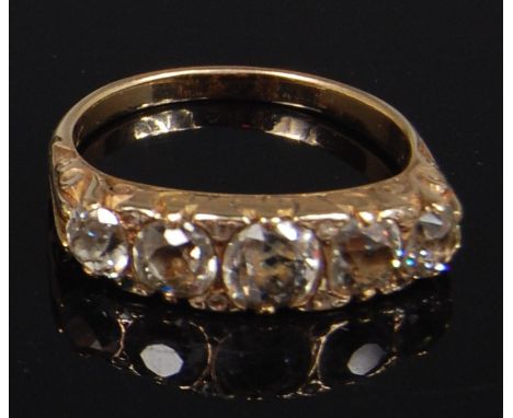 An Edwardian yellow metal and diamond set dress ring, arranged as five graduated old brilliants in a chased setting, the larg