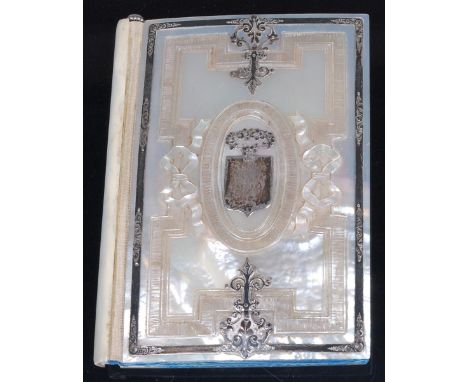 An 19th century mother of pearl, and silver mounted notebook, the convex cover with geometric and ribbon carving, the silver 
