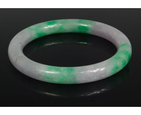 A Chinese polished celadon and green jade bangle, 8.6cm