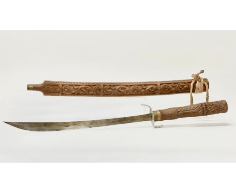 A large 20th Century Southeast Asian carved teak Dha sword. Probably Indonesia. 98cm