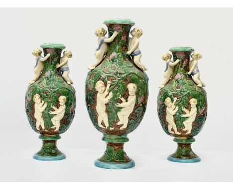 A set of 3 Late 19th Century Majolica putti and ivy leaf baluster vases. Attributed to William Brownfield. 37.5cm. 30cm.