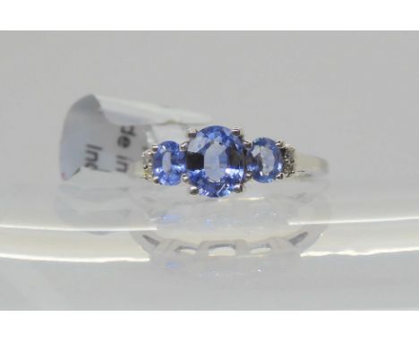 A 9ct white gold three stone tanzanite and diamond accent&nbsp; ring, finger size K, weight 2.5gms Condition Report:Available