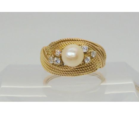 A bright yellow metal ring with a woven texture set with diamonds and a pearl, set with estimated approx 0.15cts of brilliant