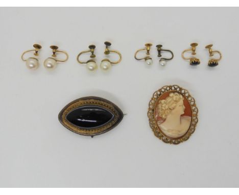 A yellow metal mourning brooch set with a bulls eye agate, with glazed panel to the reverse, a 9ct gold mounted cameo brooch,