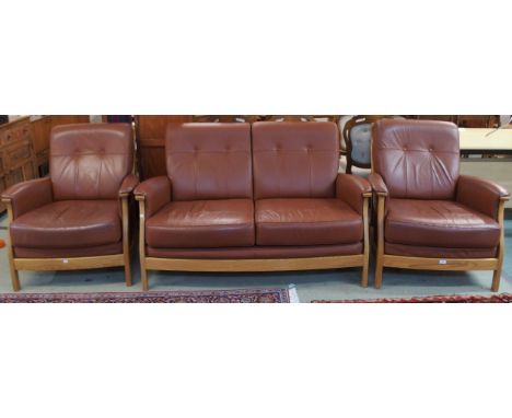 A contemporary Ercol elm and beech framed and chocolate brown leather upholstered three piece suite consisting two seater set