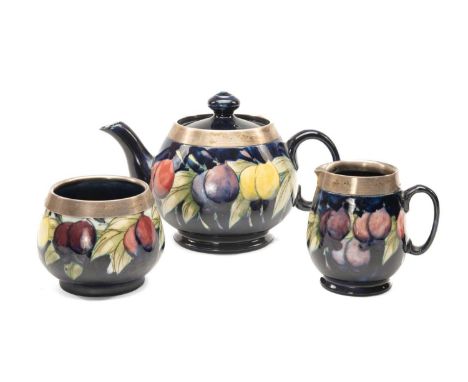 MOORCROFT SILVER MOUNTED 'WISTERIA' PATTERN TEASET, solid dark blue ground, comprising milk jug, sugar basin and teapot, suga