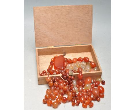 A collection of various loose carnelian red stone beads of various sizes and shapes to include round, oval, threaded and loos