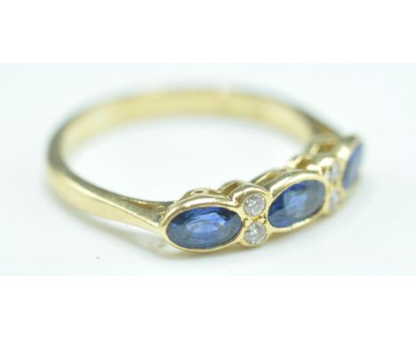 A hallmarked 18ct gold sapphire and diamond seven stone ring. The ring set with three oval mixed cut sapphires ( measure appr