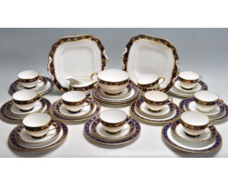A vintage late 20th century fine bone china tea service by Aynsley comprising of cups saucers, cake plates, creamer jug and m