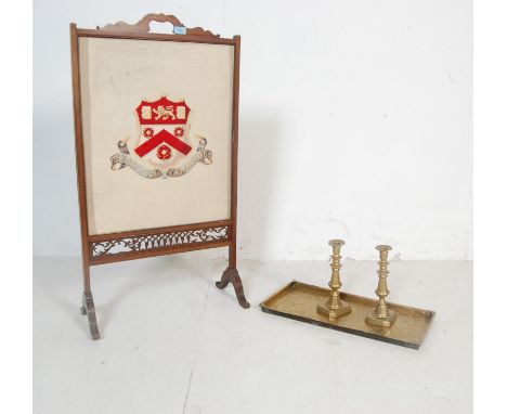 An early 20th century Edwardian mahogany fire screen having Trinity college Cambridge shield embroidery to the front, arched 