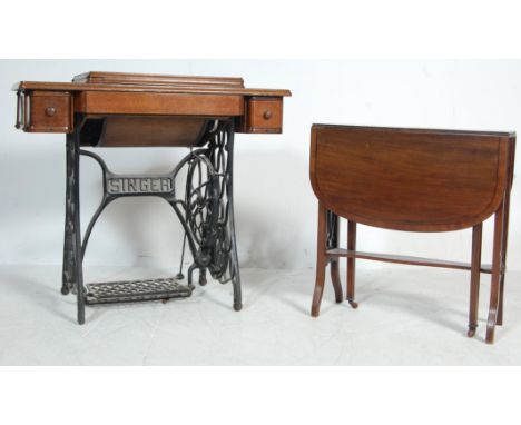 A vintage 1950s mid century oak and cast iron Singer sewing machine table having an ebonised and gilt sewing machine with Gre