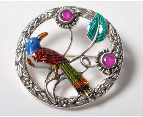 A stamped .925 sterling silver brooch having a polychrome enamel bird to the centre, semi precious stones set in flowers, set