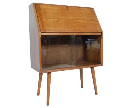 A vintage 1960’s retro light oak veneer bureau desk. The desk having a fall front top opening to reveal a fitted interior abo